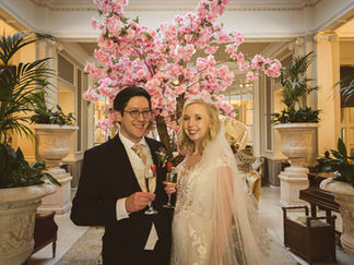 a bride and groom in front of some pink flowers