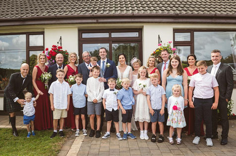 a large wedding family group outside the brides house