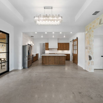 Open-concept living room in a Salado, TX custom home, featuring high ceilings, and a cozy fireplace.