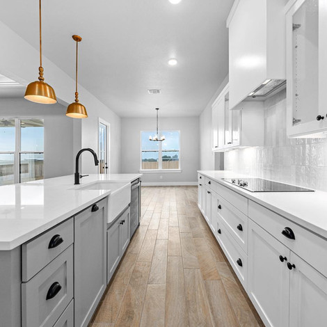 Custom kitchen in Salado, TX, with a large island, quartz countertops, and high-end finishes, designed for modern living.