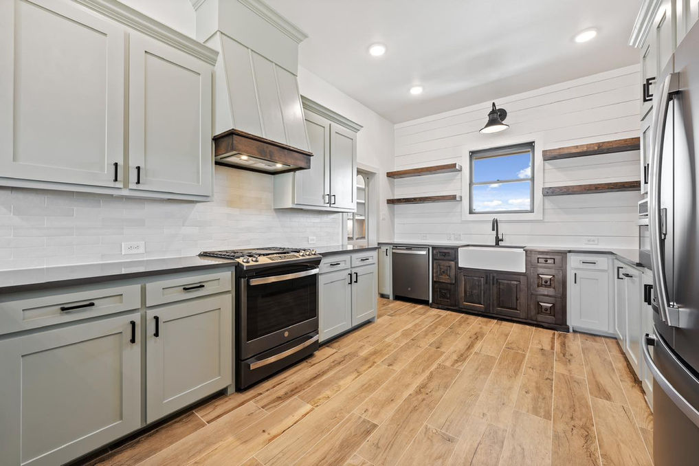 Custom kitchen in Salado, TX, with a large island, quartz countertops, and high-end finishes, designed for modern living.