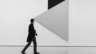 Man looking at modern art that looks liek an arrow