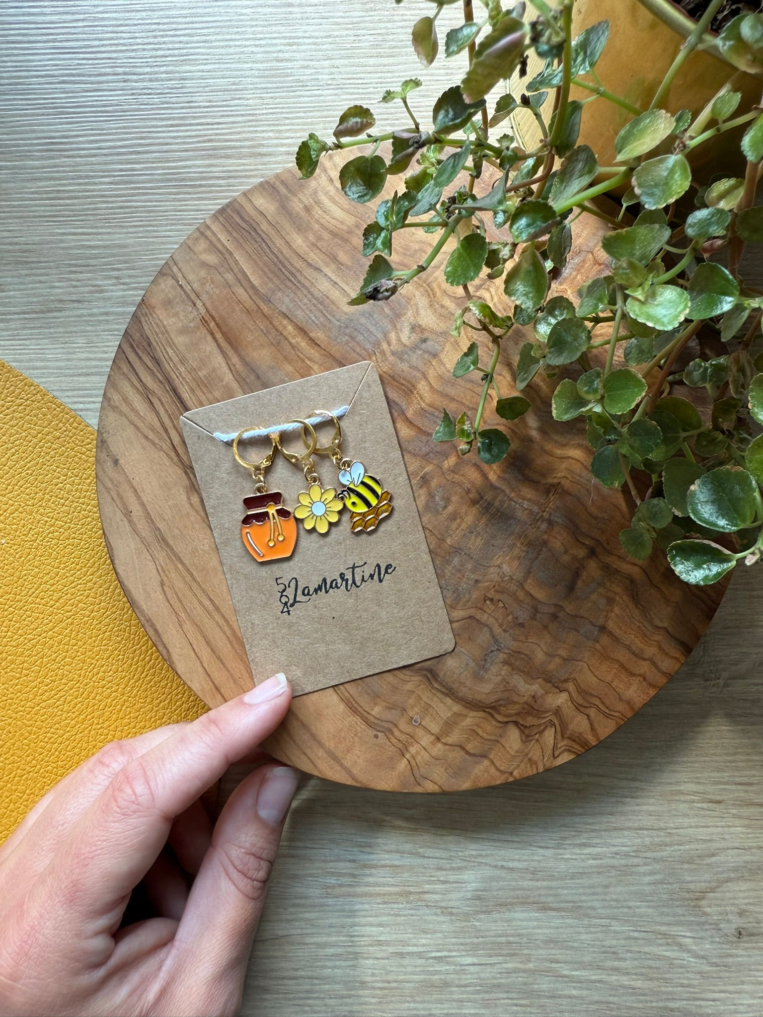 Marqueurs de rangs faits main sur le thème Miel & Abeilles : pot de miel, fleur et abeille émaillés, posés sur fond bois.