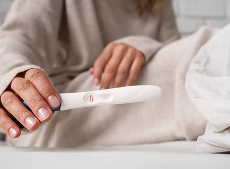 front-view-woman-holding-positive-pregnancy-test.jpeg