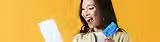 happy woman holding credit card and ipad