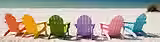 Adirondack chairs facing the ocean on the beach