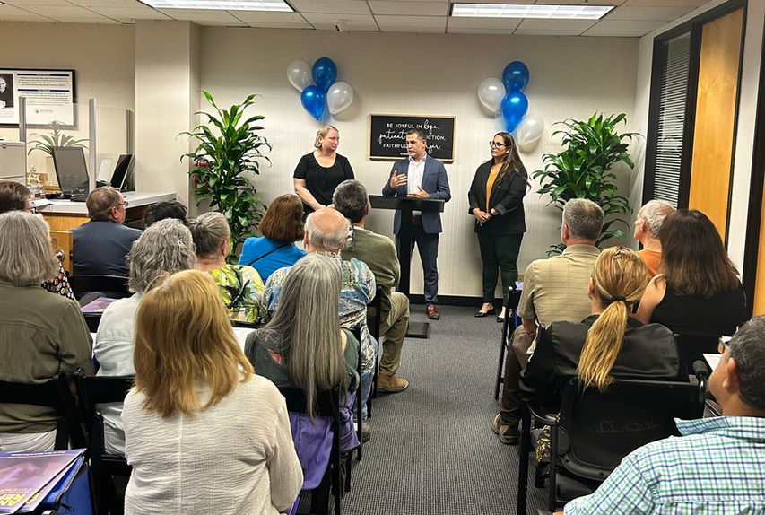 Speaker addressing a community gathering in an office.