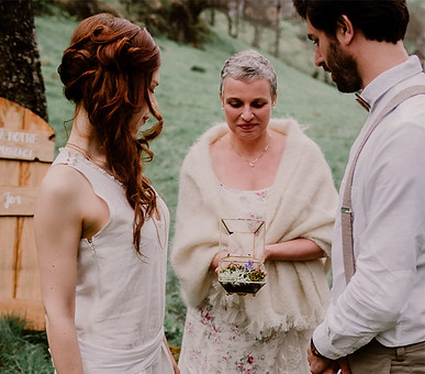 Cérémonie d’elopement intimiste en pleine nature avec le couple et l’officiante tenant un écrin symbolique