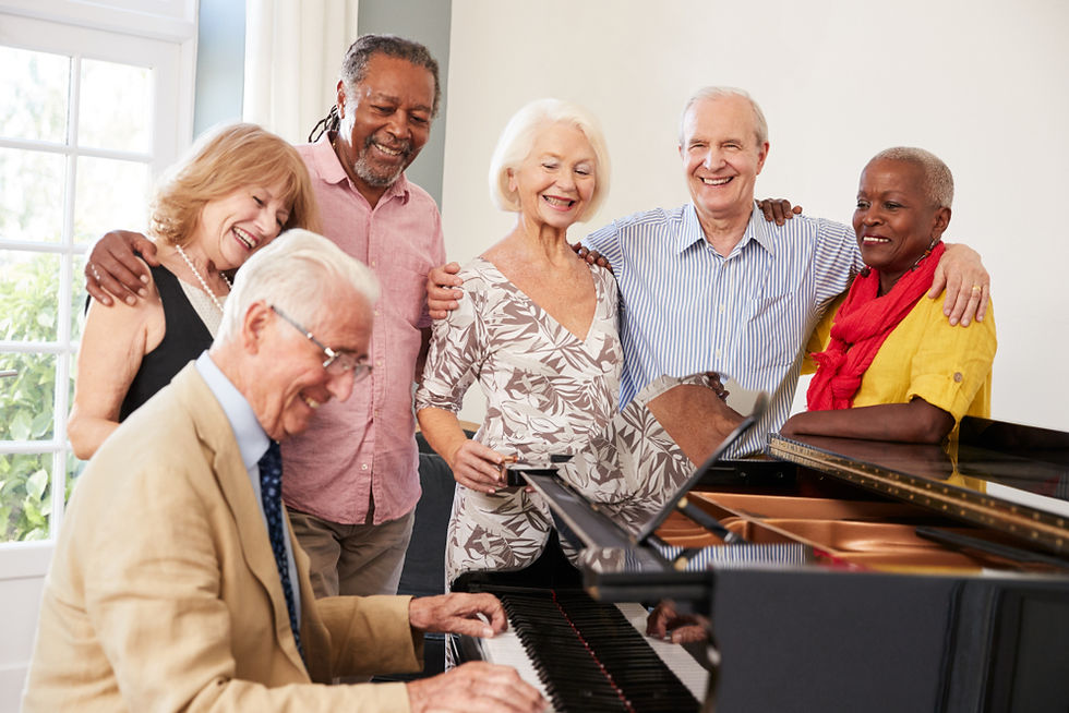 Senior man playing piano for friends at Chateau at Heritage Square, a 55+ community near Brockport NY