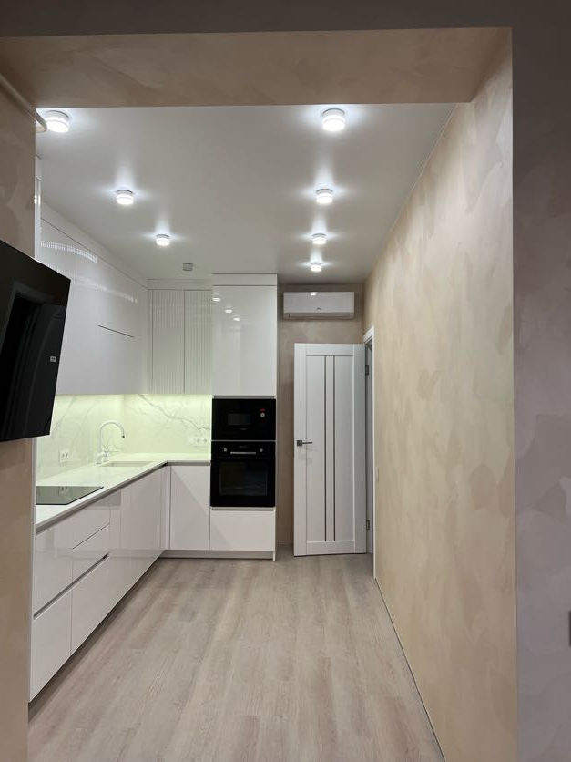 Сучасна біла кухня з духовкою та освітленням, проєкт квартири. Key4Comfort.