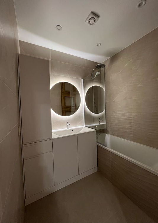 Сучасна ванна кімната з двома дзеркалами, ванною та білими меблями. Key4Comfort.