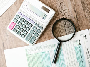 Calculator and documents on a desk, illustrating construction cost control in Switzerland