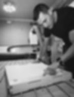 Furniture maker, Darren O'Neill, inspecting CNC-cut birch plywood joinery in a workshop, part of the bespoke manufacturing process at Koa Design.