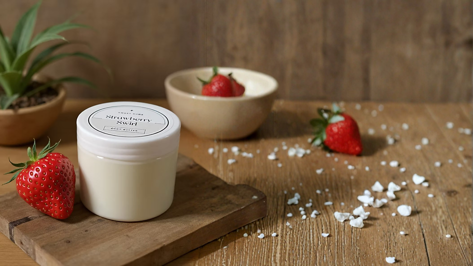 Strawberry body butter jar on wooden surface with berries