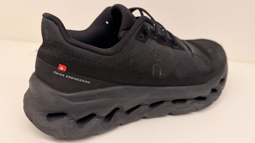 黒いスニーカーが白い背景に置かれている。スイスの国旗と「SWISS ENGINEERING」というテキストが側面にあり、現代的なデザインで力強い印象を与える。