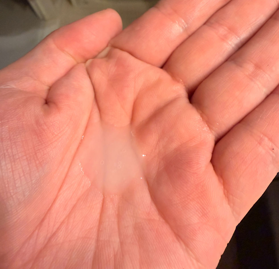手のひらに透明な液体が少量載せられている。背景はぼやけており、穏やかな雰囲気。