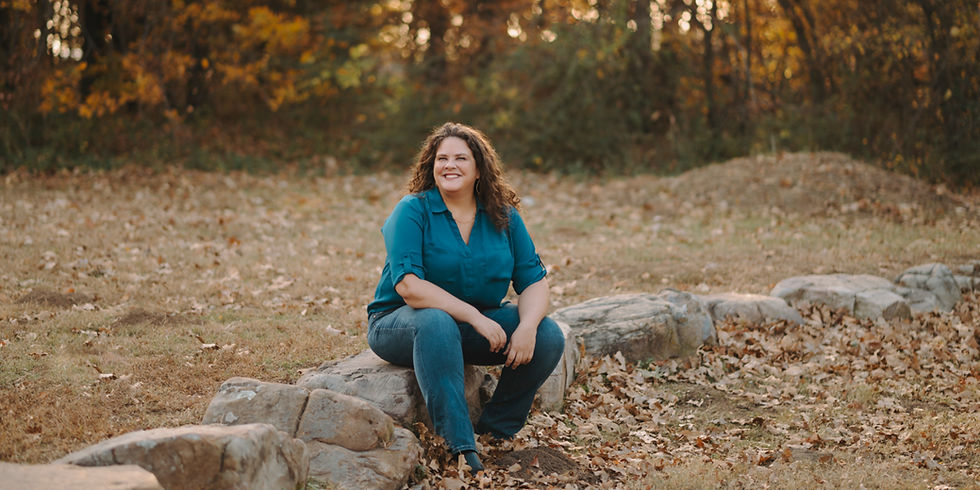Artist Jessica Thompson, sitting outdoors on a rock, enjoying nature