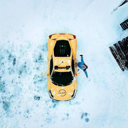 Aerial shot of a yellow sports car on snow, an attention-grabbing hook that stops the scroll