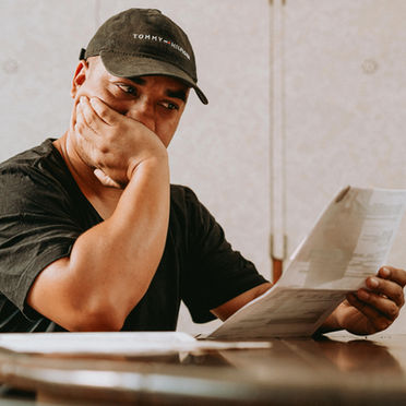Concerned man reviewing financial documents and IRS notices at home
