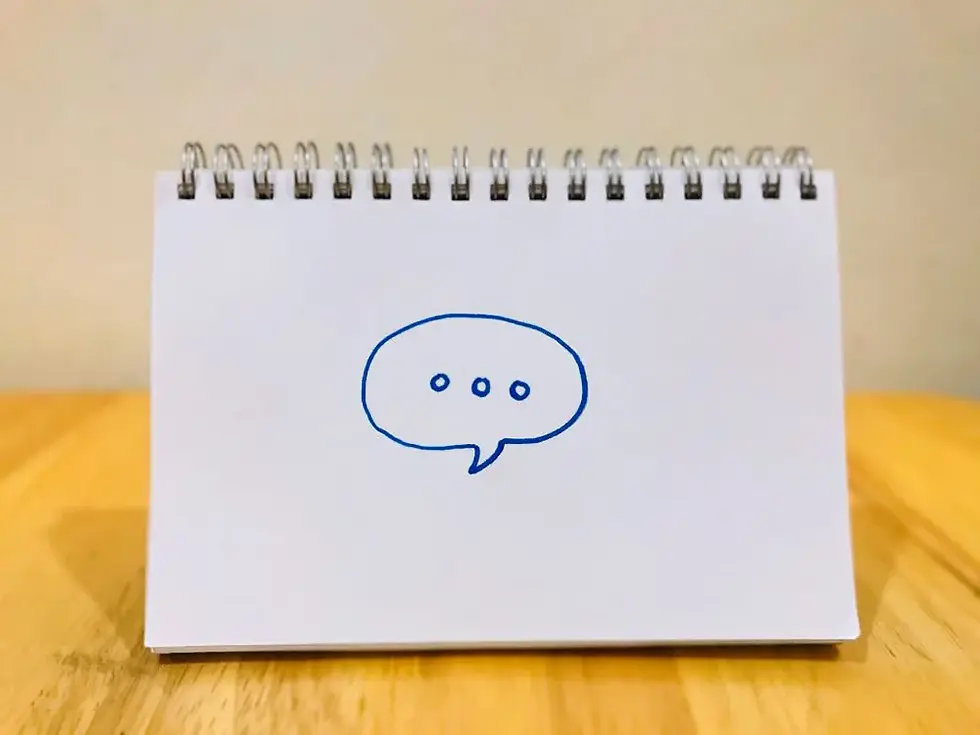 Ilustración de un globo de diálogo sobre un cuaderno, símbolo del lenguaje y la conversación en el coaching ontológico para transformar la realidad.