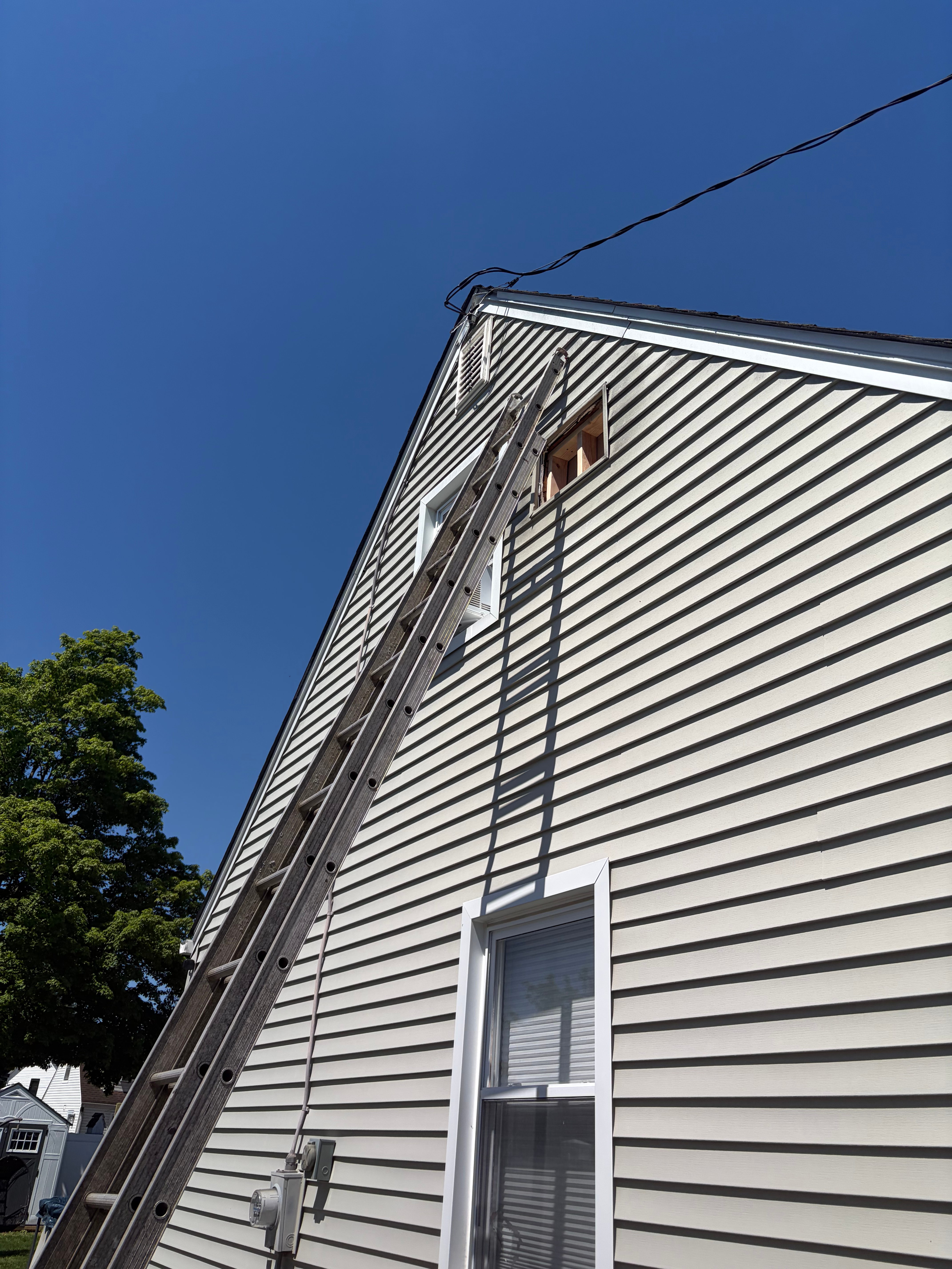 Exterior siding work in Bergen County, NJ — extension ladder set against vinyl siding for prep, paint, or trim repair