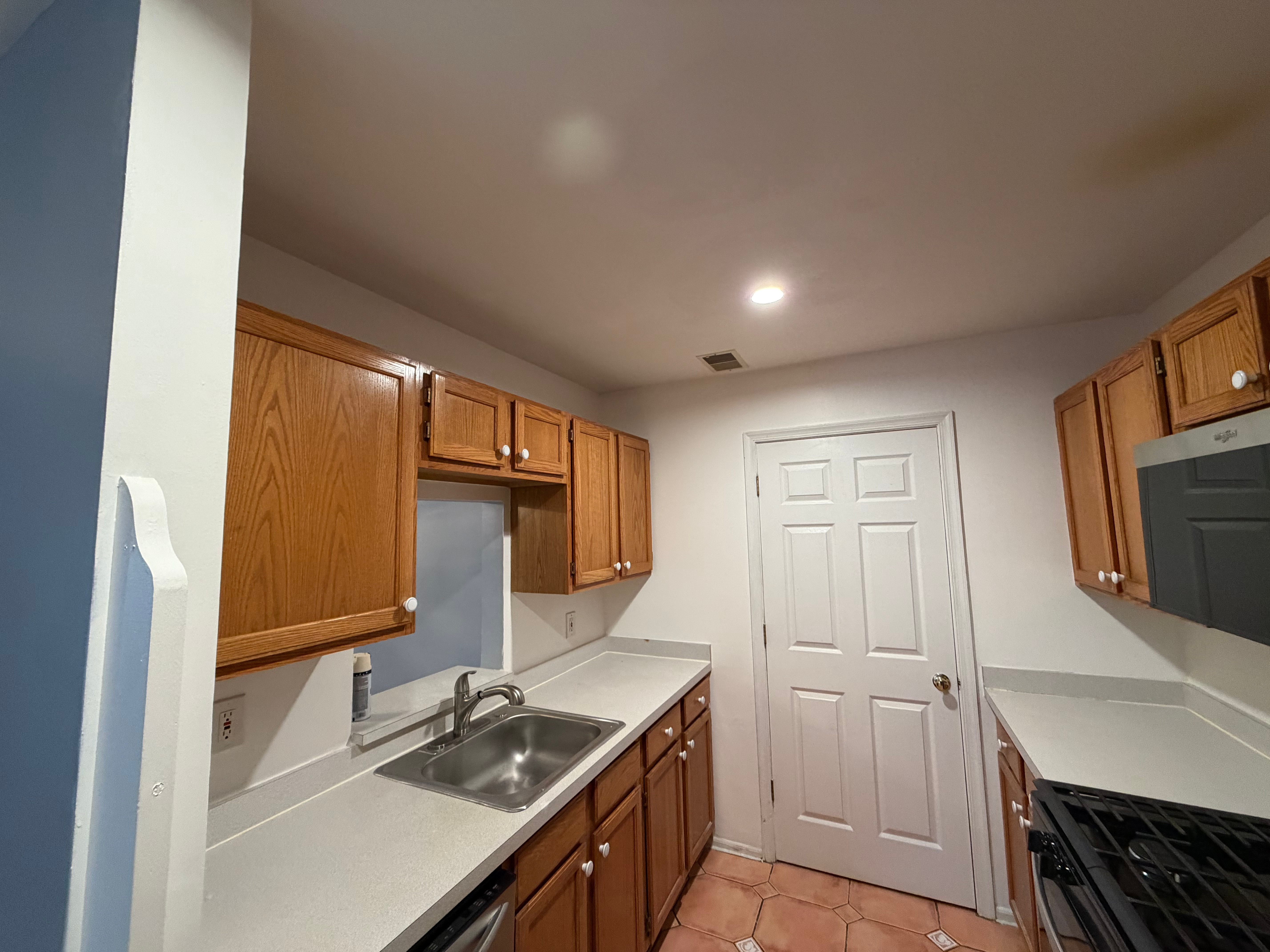Kitchen flooring refresh in Bergen County, NJ — terra-cotta tile-pattern flooring with new appliances above