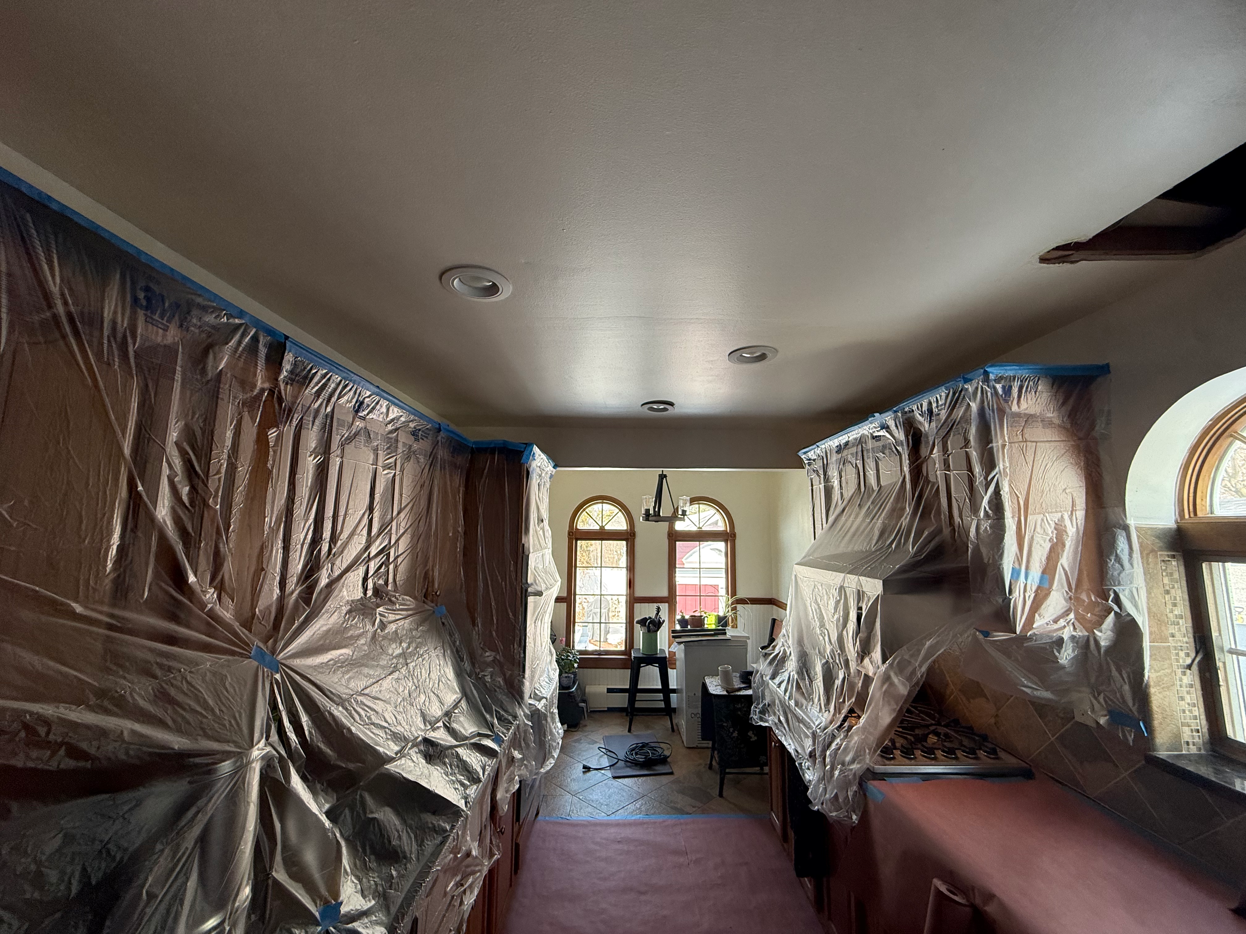 Kitchen prep for paint in Bergen County, NJ — full plastic protection over cabinets and counters before any finish work begins
