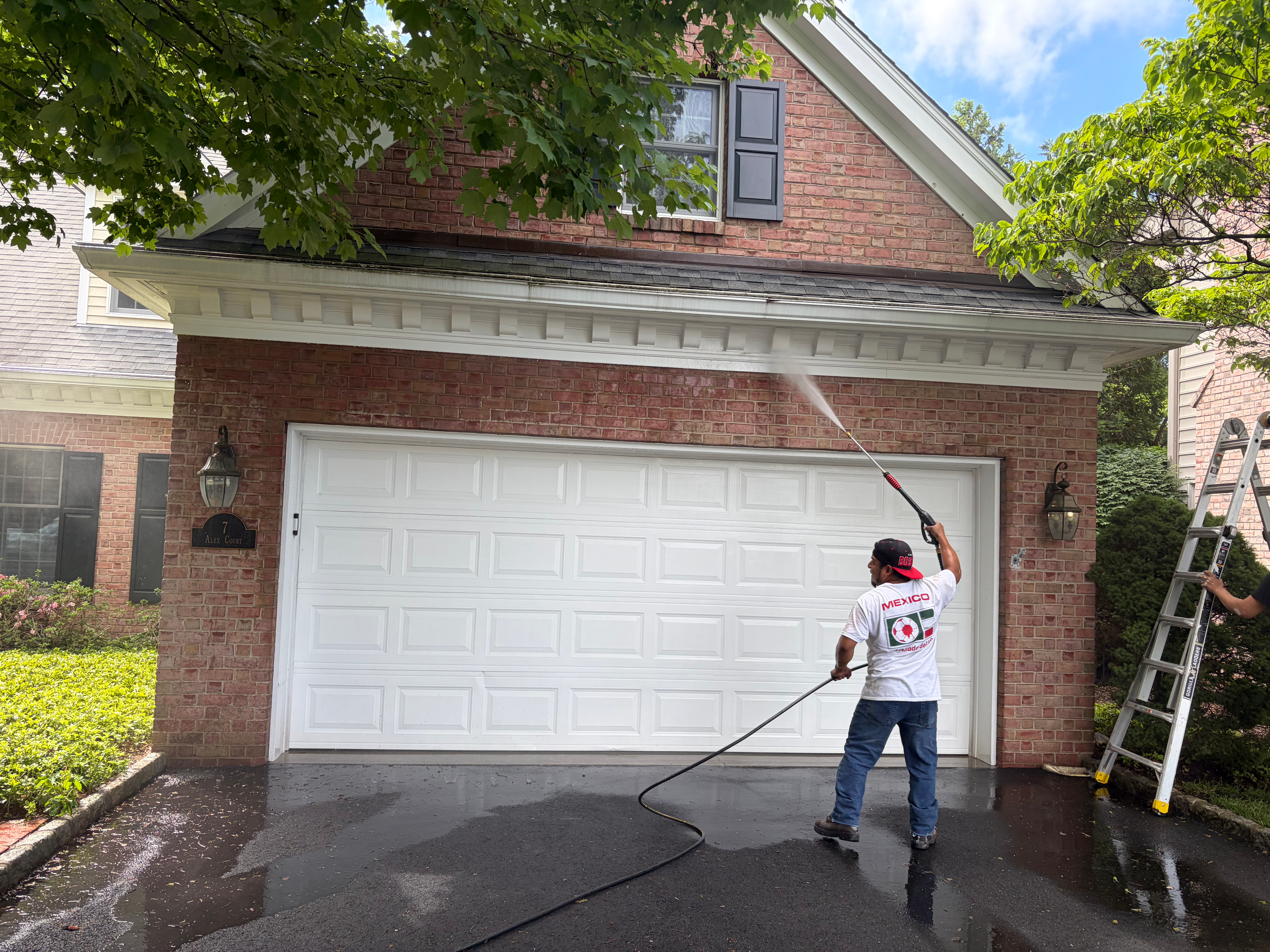 Property maintenance power washing in Bergen County, NJ — HomeGrown Roots & Repairs cleaning brick exterior and trim with soft-wash technique