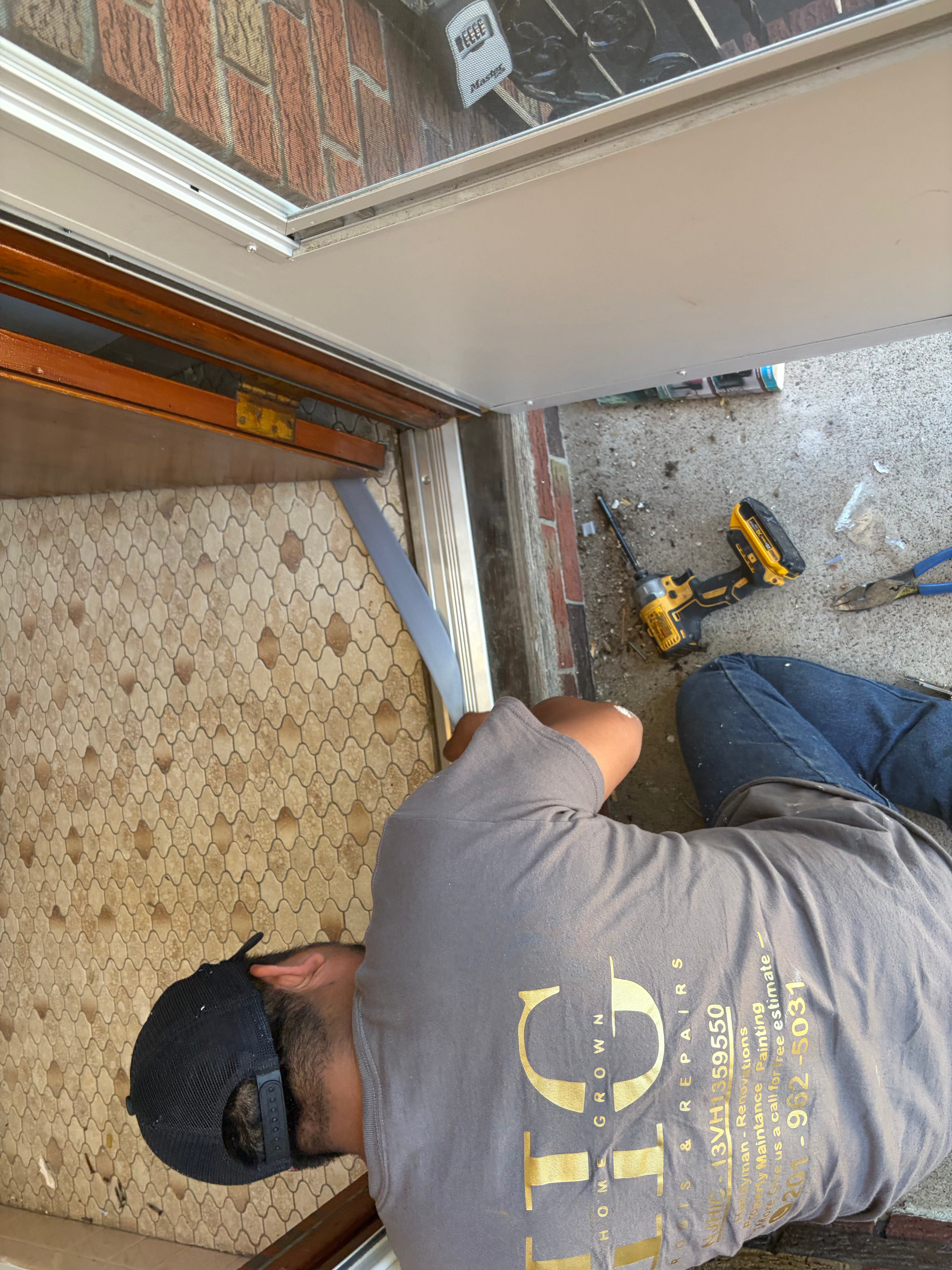 Door threshold and weatherstripping handyman repair in Bergen County, NJ — HomeGrown contractor working with cordless drill and precision tools