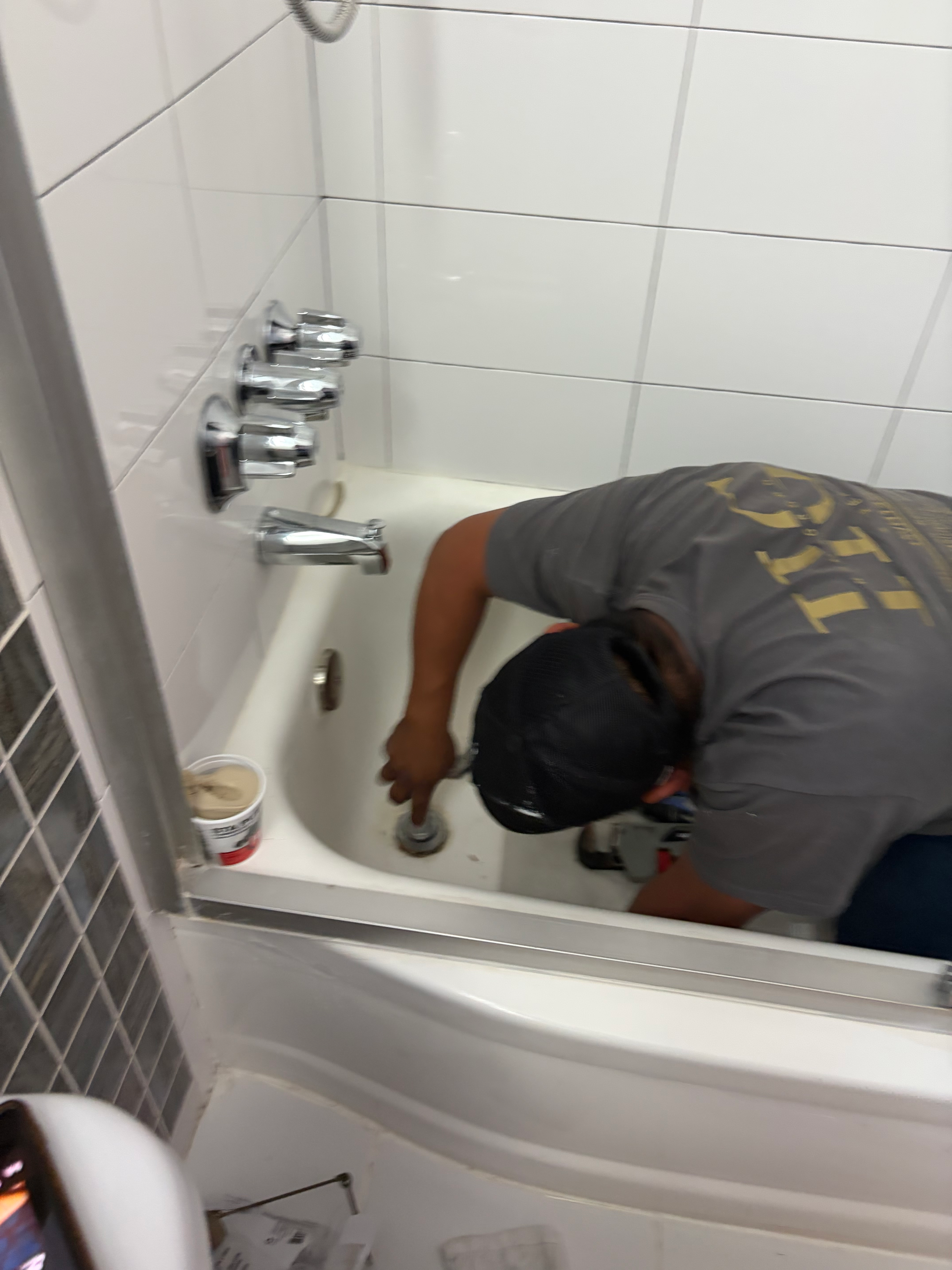 HomeGrown Roots & Repairs licensed NJ contractor (#13VH13595500) repairing a bathtub drain during a Bergen County bathroom remodel