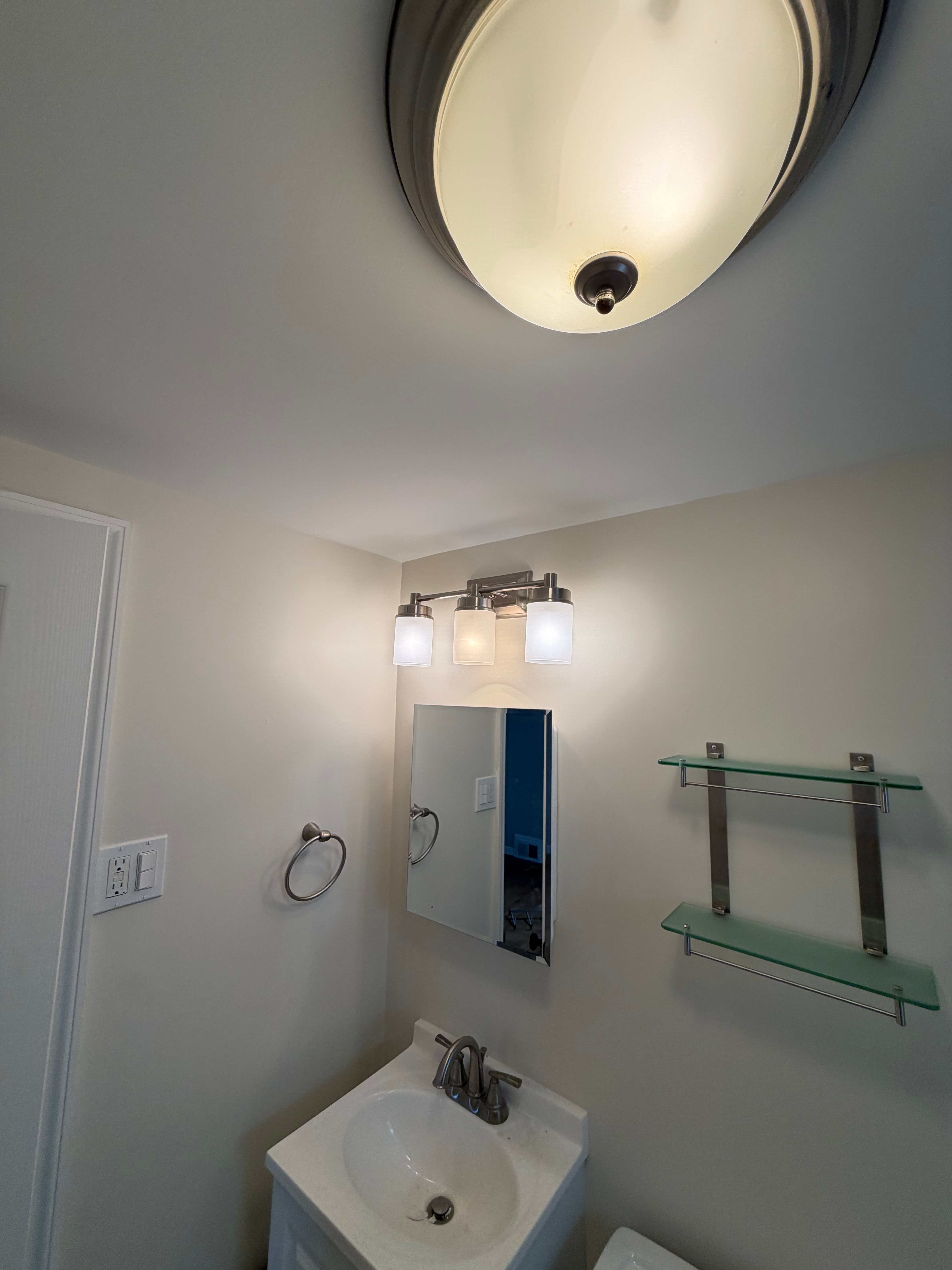Bathroom remodel in Bergen County, NJ — subway tile shower, new vanity, and brushed-nickel sconces