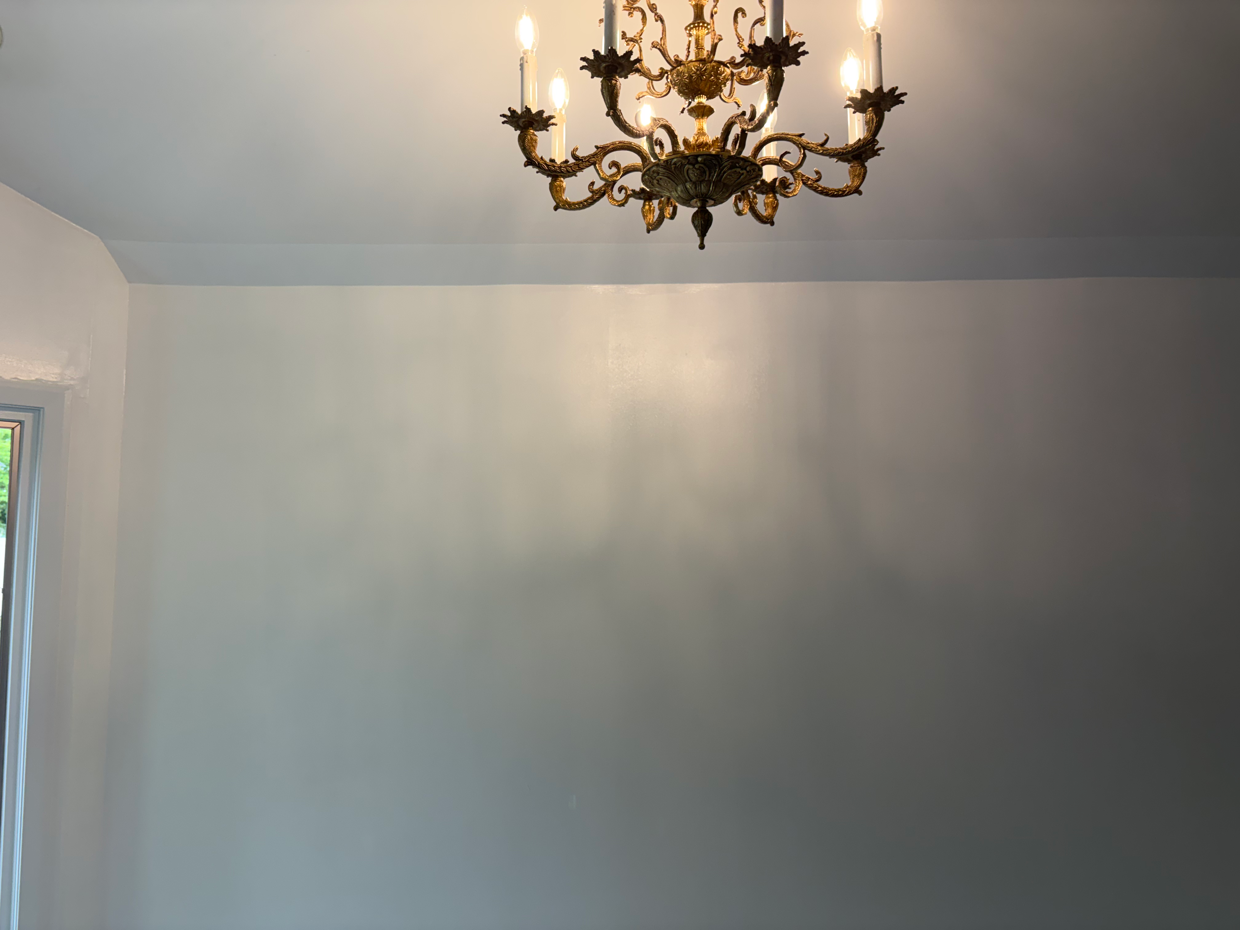 Interior painting in Bergen County, NJ — fresh gray walls under an ornate chandelier with crisp cut-in at the ceiling line