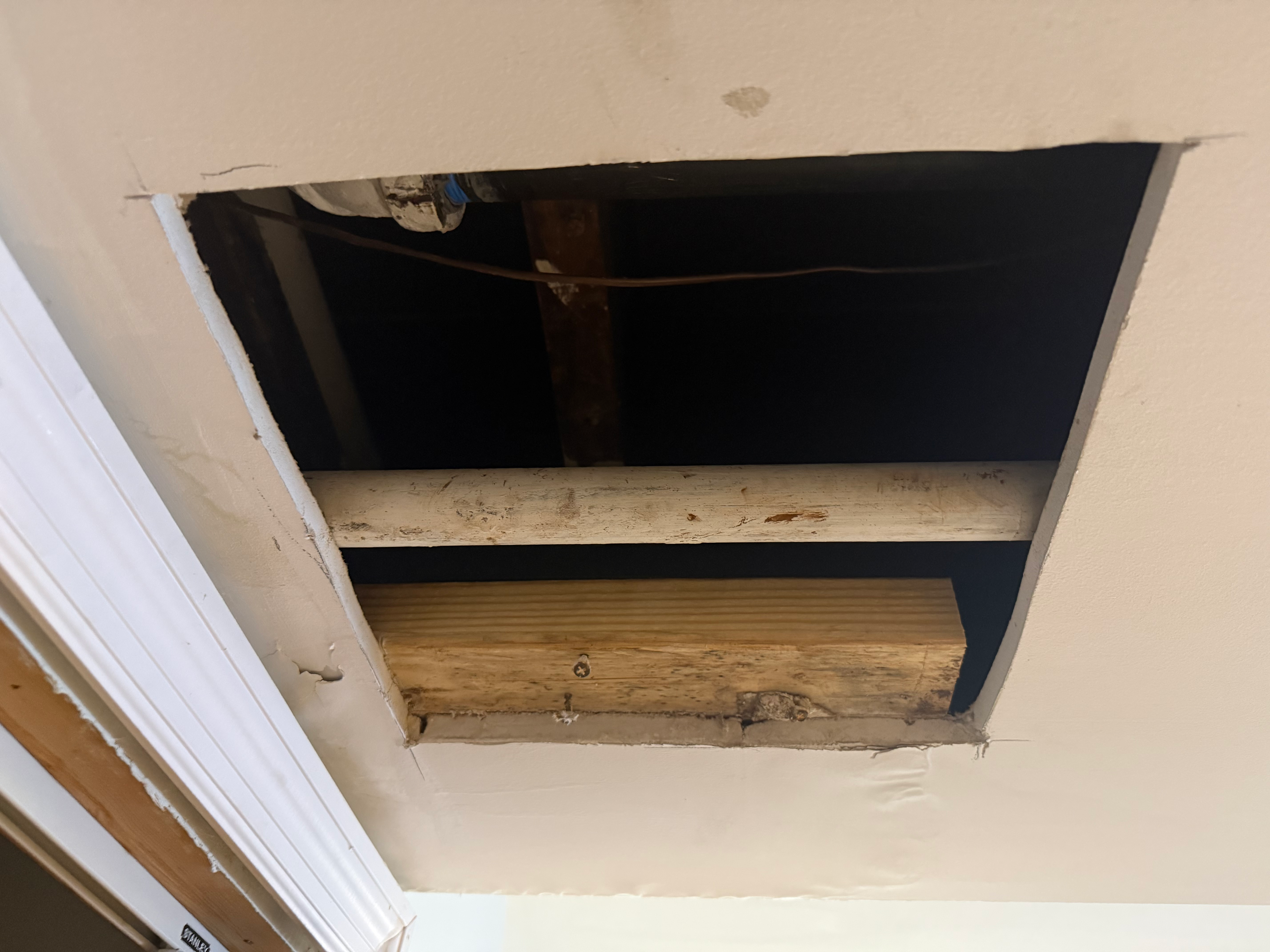 Drywall ceiling opening showing exposed joists in Bergen County, NJ — pre-patch framing prep for replacement drywall