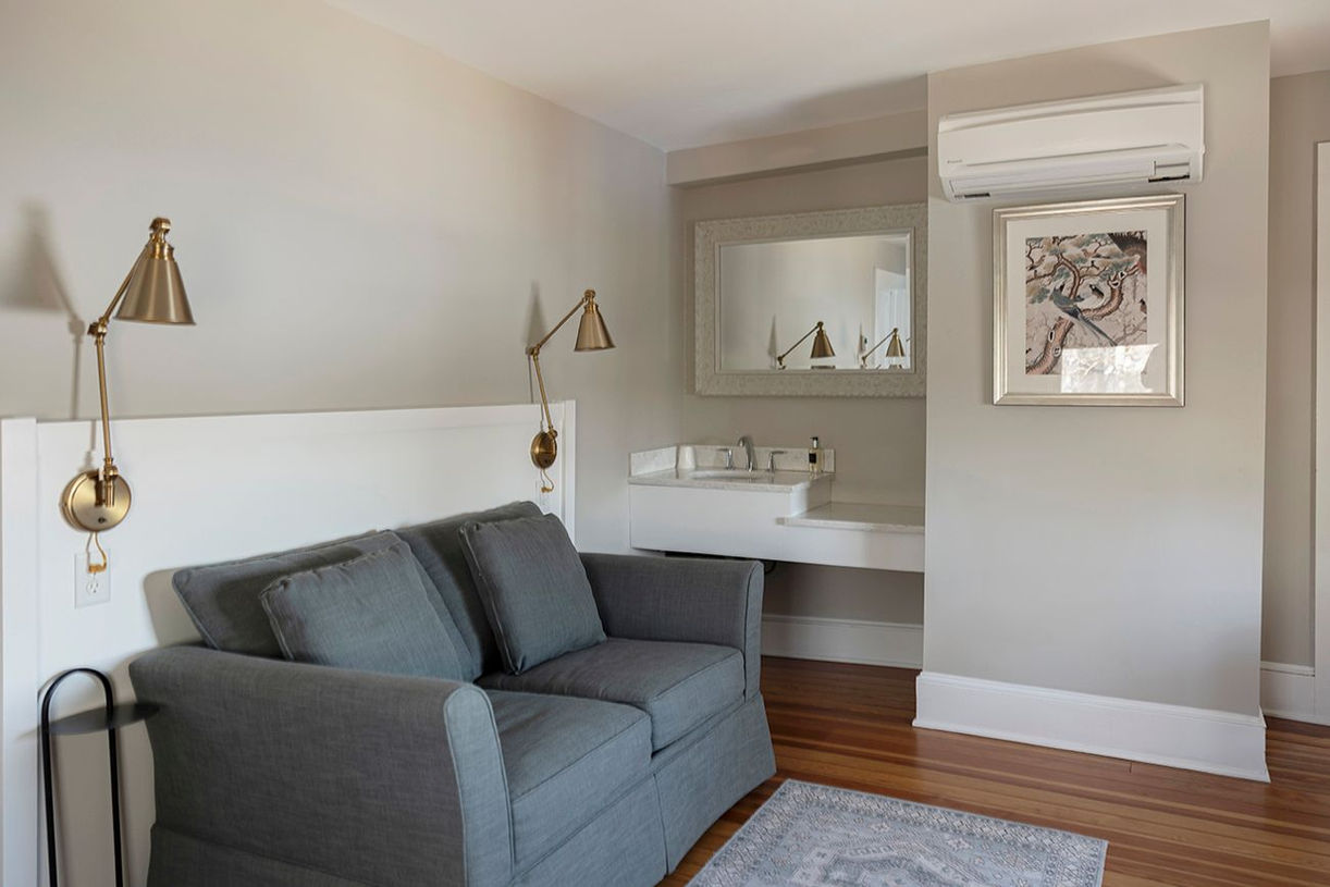 Room 38 | The Laurel Lake View King Suite at Lakehouse Inn featuring stunning lake views, king-sized bed, electric fireplace, spacious living room with pull-out sofa, and luxurious bathroom with double vanity