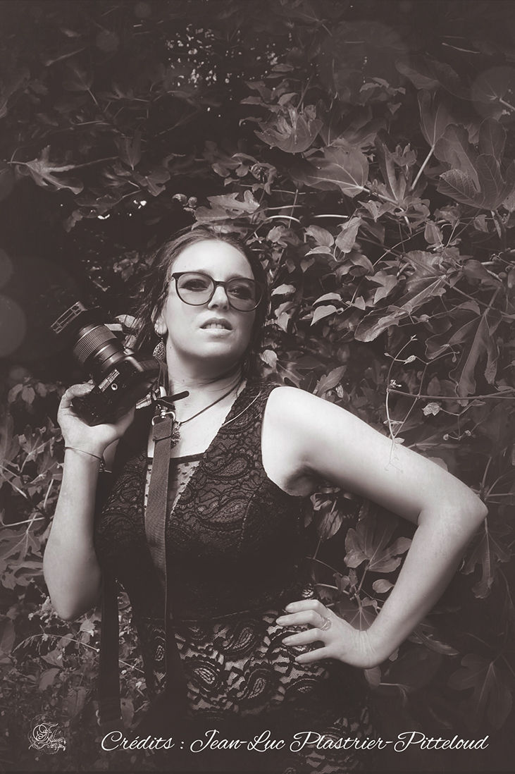 Femme blonde porte des lunettes, Reflets De Fawn, posant devant la végétation.