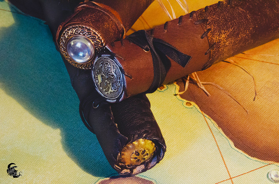 Botines en cuir ornés d'un bijou et d'une pièce de monnaie sur carte.