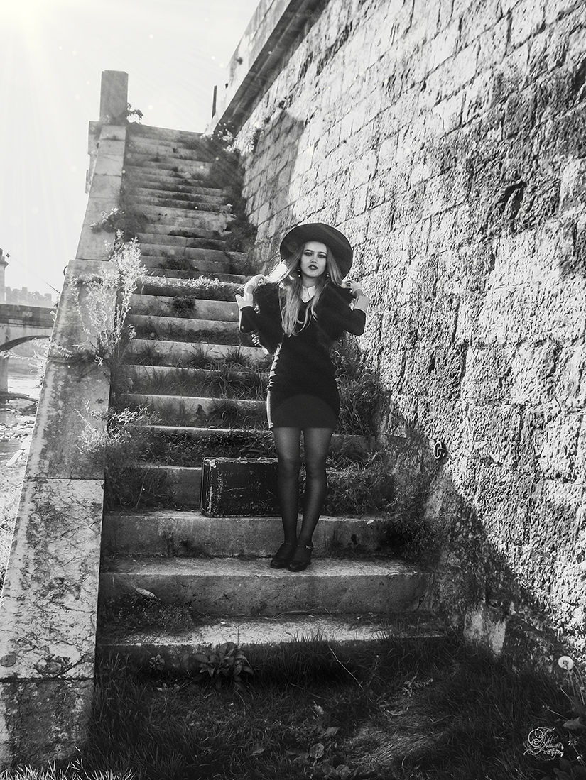 Femme sur un escalier en pierre, portant un chapeau et une robe, Reflets De Fawn.