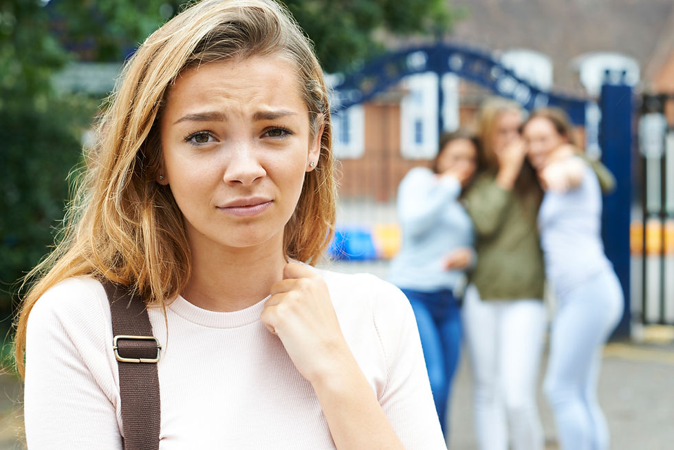 Image of a young teen girl upset while three other teen girls point and whisper about her | therapy for teens in new york, ny | teen therapist in new york, ny | online therapy for teens | anxiety in teens | teen depression | 10003 | 10021 | 10023