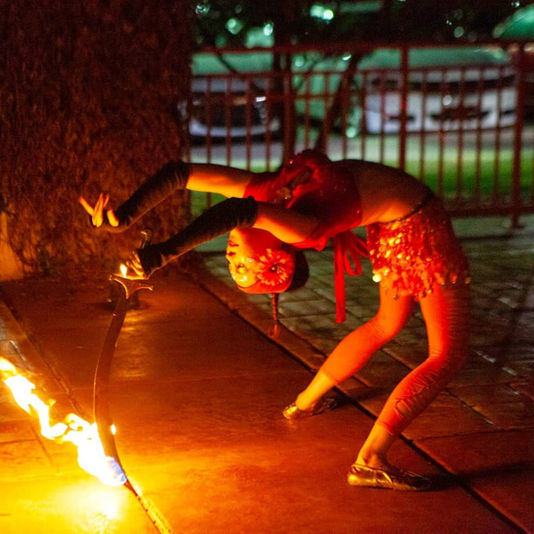 Mystica Fay performing fire belly dance at a corporate event with fire sword