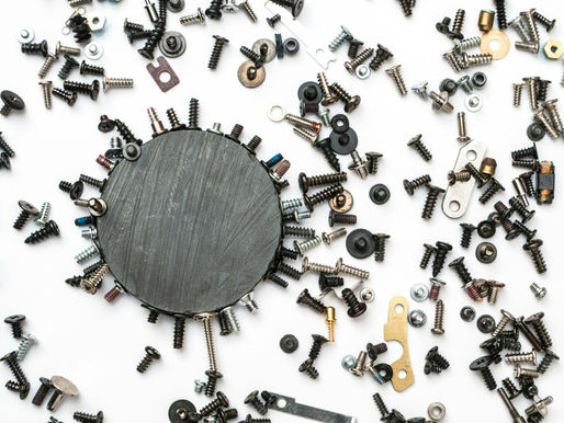 Round magnet with nails, screws and other metal objects attached to or surrounding it