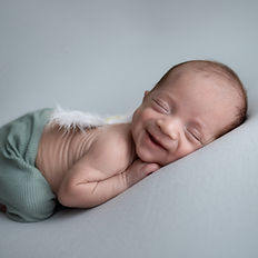 A newborn surrounded by gentle hues, creating a serene and timeless image.