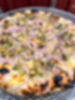 Wood-fired pizza with red onions and pistachios