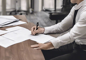 Two people signing documents in office.jpg