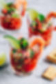 Refreshing Mexican Shrimp Cocktail with lime in glass on gray stone background, copy space