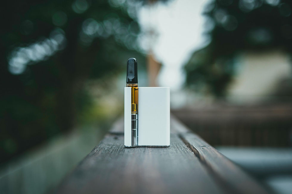 Vape device on a wooden railing with a blurred green background. The white device is upright, creating a calm, focused scene.