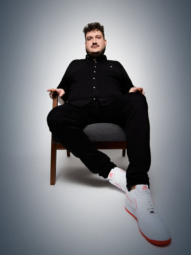 Ganzkörper-Portrait von Robijn auf einem Stuhl in relaxter Pose, der Stil ist an die Arbeiten von Platon angelehnt.