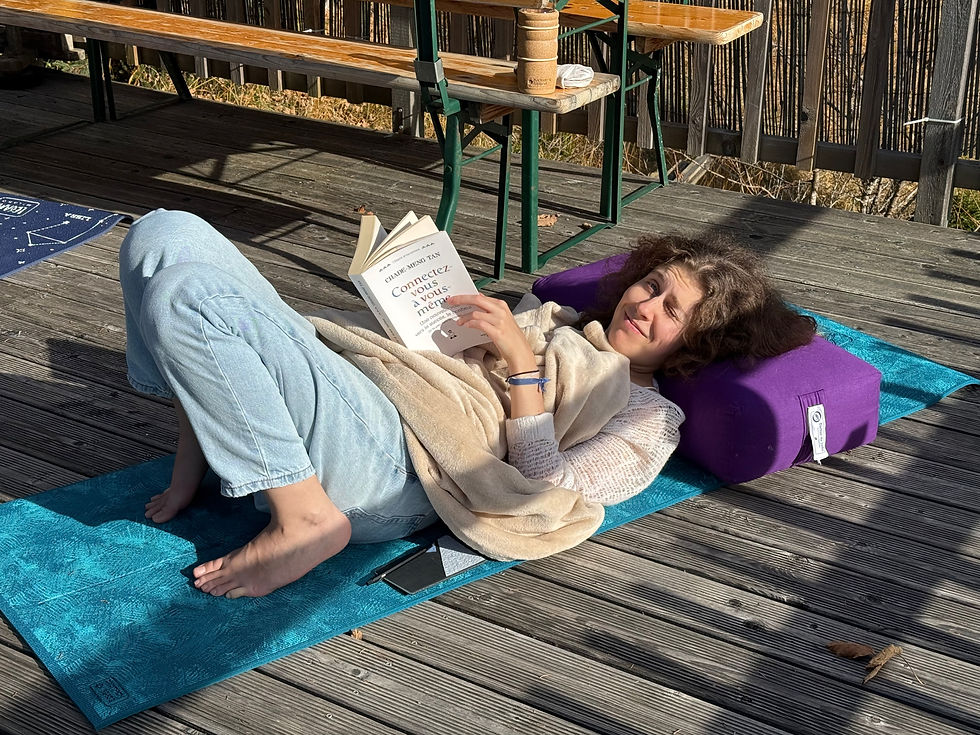 Femme méditant en pleine nature sur une couverture, avec montagnes et lacs alpin en arrière-plan, pratique de la retraite méditation suisse romande.