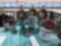 an image of a bowling alley table with three bowling pins decorated with gold and maroon ribbons next to a donation bin