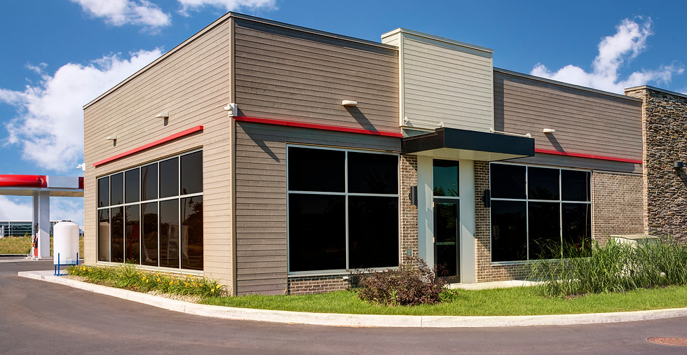 Modern Dunkin' building with a large glass facade and a beige brick base with architectural design new construction Ludlow
