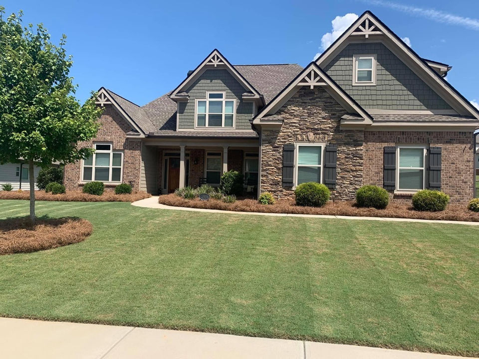 Home with lawn maintenance and fresh pine straw.